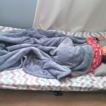Child sleeping on a portable toddler cot