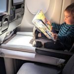 Child sitting on a Flyaway kids bed on a plane